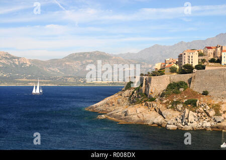 Around Corsica - A private yacht passing the Citadel on it's way to the marina in Calvi Stock Photo