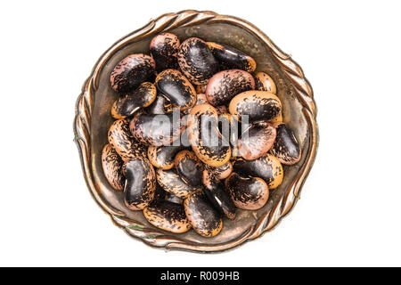 Lot of whole speckled colored butter beans painted lady scarlet runner variety in old iron bowl flatlay isolated on white background Stock Photo