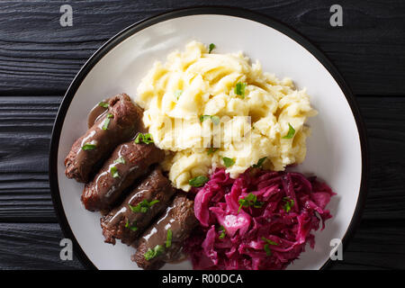 German beef rouladen recipe, along with mashed potato and red cabbage close-up on a plate. Horizontal top view from above Stock Photo