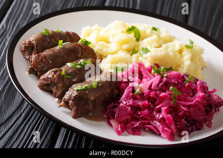 Beef Rouladen with gravy on a plate served with mashed potatoes and red cabbage close-up on the table. horizontal Stock Photo