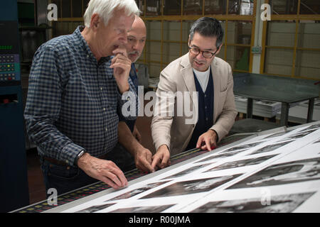 Dewi Lewis British photography book publisher on press publishing My British Archive, The Way We Were 1968-1983 at EBS Verona Italy. Jonathan Bortolazzi MD (right in white tshirt ) Italian printer (centre) of EBS looking at page proofs. 2018 HOMER SYKES Stock Photo