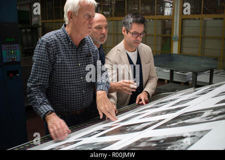 Dewi Lewis British photography book publisher on press publishing My British Archive, The Way We Were 1968-1983 at EBS Verona Italy. Jonathan Bortolazzi MD (right) Italian printer (centre) of EBS looking at page proofs. 2018 HOMER SYKES Stock Photo