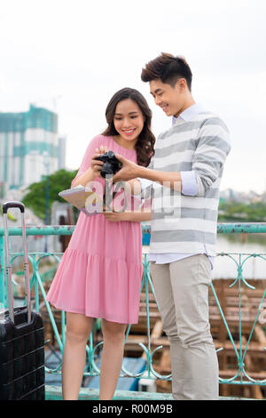 Happy young couple of travellers holding map in hands Stock Photo