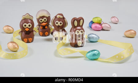 Four Easter chocolates cartoon characters  figures compositionswith yellow ribbon and Easter eggs Stock Photo