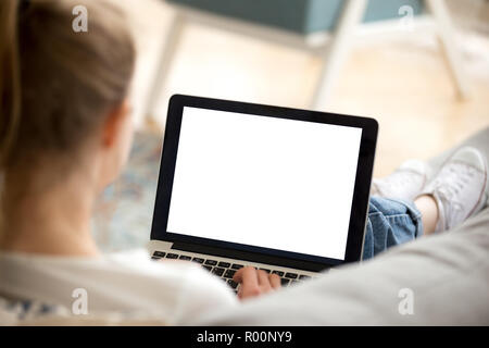 Girl using laptop sitting on couch at home Stock Photo