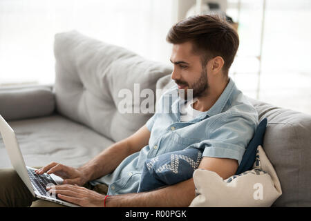 Young man working using laptop at home Stock Photo