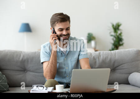 Cheerful male talking by mobile phone indoors Stock Photo