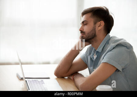 Side view man sitting at the desk at office sleeping Stock Photo