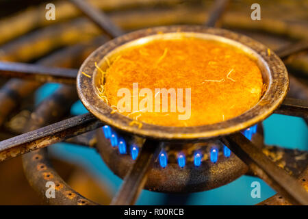 Kunefe is cooked on burning gas stove hob blue flames in Hatay, Turkey Stock Photo