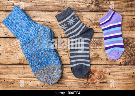Socks on wooden background. Knitted socks for the cold season and colored socks for summer shoes. Stock Photo