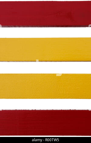 Four parallel wooden boards painted in red and yellow on a white background Stock Photo