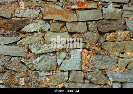 Detail of multicolor stone wall with coarse formless colored stones Stock Photo