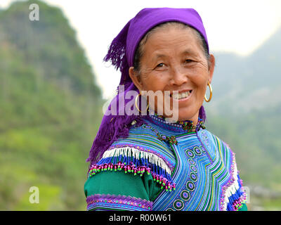 Elderly Vietnamese Blue H’mong hill-tribe woman wears embroidered traditional attire in blue. Stock Photo