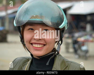 Smiling Vietnamese scooter girl with modern motorcycle crash helmet. Stock Photo