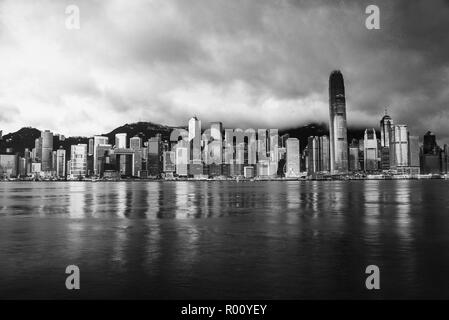 Skyline of Hong Kong in the morning. Beautiful skyscrapers with colorful sunrise sky. Black and white Stock Photo