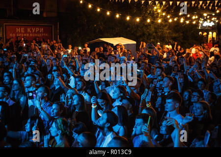 KIEV-11 JULY,2018: Group of young people taking photos with smart phones on summer music festival Bazat at night. Concert crowd in bright blue lights  Stock Photo
