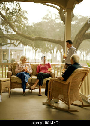 Family members socializing together on a suburban porch. Stock Photo