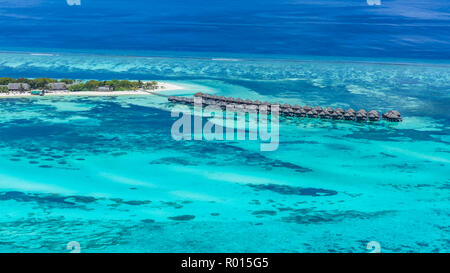 Aerial drone bird's eye view photo of Maldives island and sea. Beautiful turquoise and sapphire clear water beach. Exotic vacation from seaplane view Stock Photo