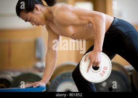 Teenage boy lifting weights. Stock Photo