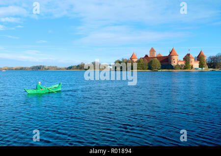 Medieval castle of Trakai, Vilnius, Lithuania, Eastern Europe, located between beautiful lakes and nature with a fisherman in a green boat Stock Photo