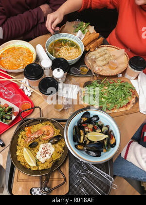 Top view of food dishes and hands, dinner, lunch together, family, friends eat, cuisine of different nations Stock Photo
