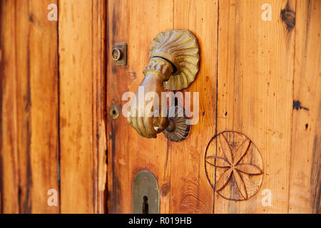 Door brass knock hand shape in Mediterranean Spain Stock Photo