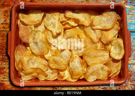 Homemade fried potatoes sliced chips in a clay pot Stock Photo