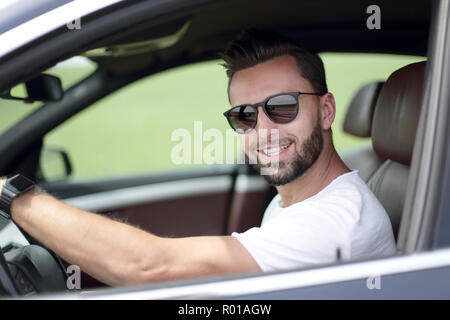 stylish young man driving a convertible car Stock Photo
