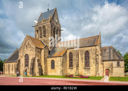 Church of Sainte-Mère-Église, Normandy, with the Parachute Memorial on the bell tower. The town played a significant part in the World War II Normandy Stock Photo