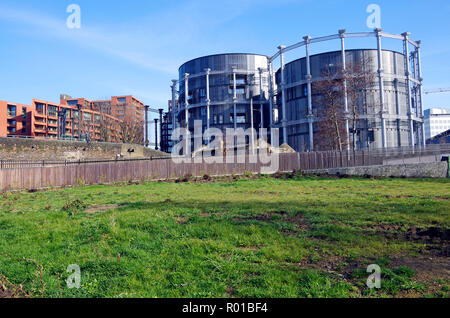 A cluster of three historic gas-holders re-erected in redeveloped rail-lands near King’s Cross modern apartments, built inside their frames Stock Photo