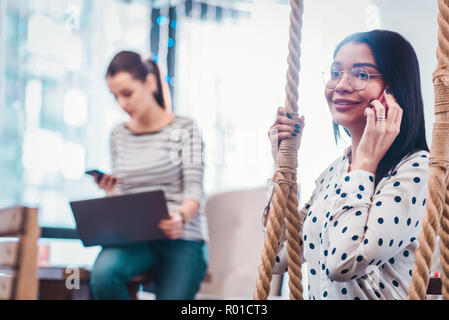 Delighted nice woman having a phone conversation Stock Photo