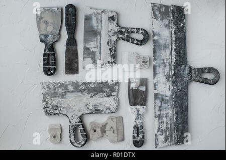 Kit of putty knives. Spatulas with the remaining mortar. Gastarbeiter or guest worker concept. Handyman. Tools for repair. Stock Photo