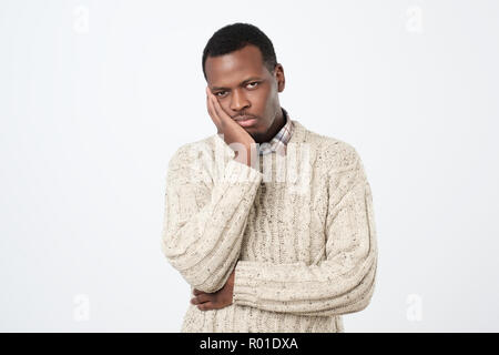 Boring, dull, tedious concept. Young african man looking at camera sadly Stock Photo