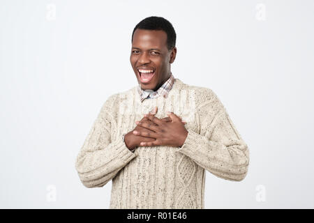 Happy friendly african man being content to hear compliment, expresses his gratitude and thanks Stock Photo