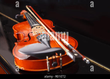 brown vintage violin with bow lying on a piano closeup indoor Stock Photo