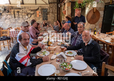 A group of people enjoying a traditional meze in the Lofou taverna, Lofou village, Cyprus.