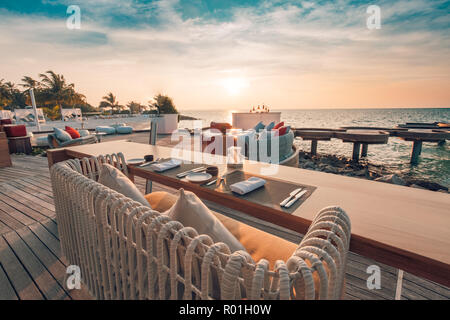 Outdoor restaurant at the beach. Table setting at tropical beach restaurant. Moody dinner set-up Stock Photo