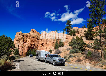 Pickup with caravan drives through a rock gate on Highway 12, Red Canyon, Dixie Forest, Utah, USA Stock Photo