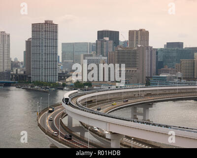 Modern highway with automobiles and train leading to a bridge. Rainbow bridge, Tokyo, Japan. Stock Photo