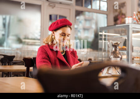 Mature appealing stylish woman feeling relaxed sitting in bakery on weekend Stock Photo