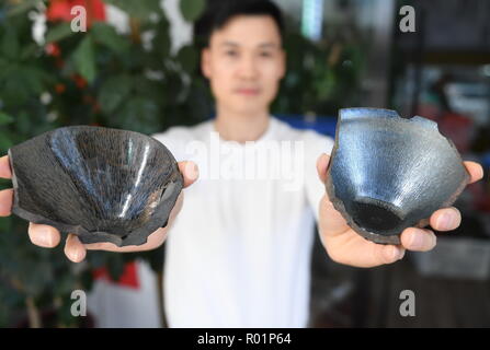 (181031) -- JIANYANG, Oct. 31, 2018 (Xinhua) -- Zhou Jianping, an inheritor of traditional firing techniques of 'Jian Zhan', a kind of black glaze bowl, shows 'Jian Zhan' fragments of Song Dynasty in Jianyang, southeast China's Fujiang Province, Oct. 29, 2018. 'Jian Zhan', a kind of temmoku glaze or black glaze porcelain, was then used only by emperors of ancient China's Song Dynasty (960-1279). Famous for its nobility and gorgeousness, 'Jian Zhan' was numerously exported overseas through the Silk Road on the sea. However, after Song Dynasty, those traditional firing techniques to make 'Jian Z Stock Photo