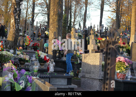 ZACHELMIE, POLAND - OCTOBER 31, 2018: A woman tends to a grave in cemetery on the eve of All Saints' Day. Credit: Slawomir Wojcik/Alamy Live News Stock Photo