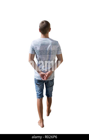 Rear view full length portrait of young man walking and stepping with hands behind his back isolated over white background. Stock Photo