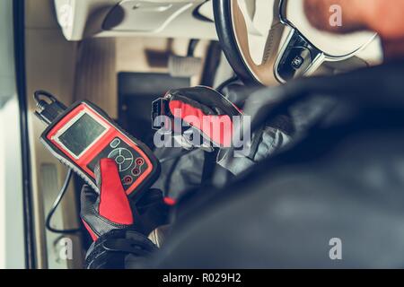 Auto Service Diagnostic Tool in Hands of Vehicle Maintenance Worker. Car Computer Error Reading Using Mobile Device. Stock Photo