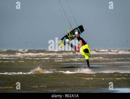 Kite surfer touches water with hand while being upside-down Stock Photo