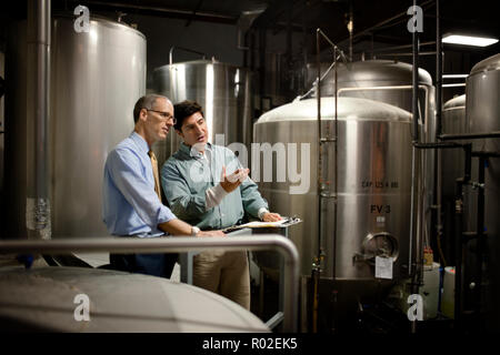 Two colleagues discussing work in a warehouse. Stock Photo