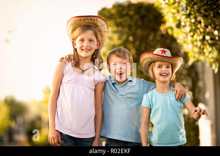 Portrait of three kids wearing cowboy hats. Stock Photo