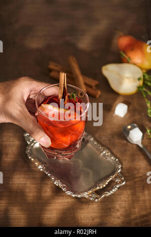 Glass of Cider pear cocktail or lemonade, cinnamon sticks, anise stars on wooden background. Stock Photo