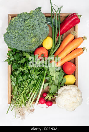 Organic healtyy food concept  of fresh colorful vegetables in a  wooden tray on a white background , flat lay , top view with copy space Stock Photo