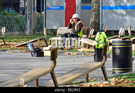 Workman having a rest in Leicester Square during replacement of the benches. London, England, UK. Stock Photo
